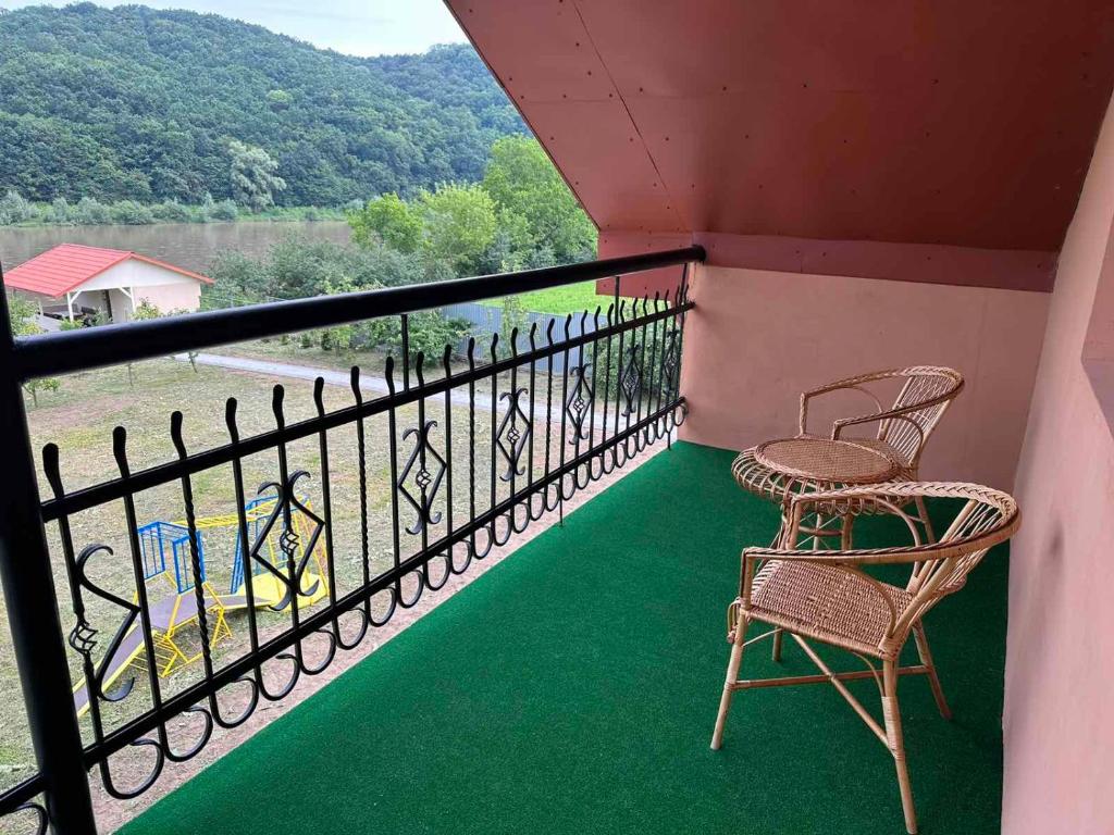 Садиба Дністер Ленд的阳台配有2把椅子和观景栏杆。