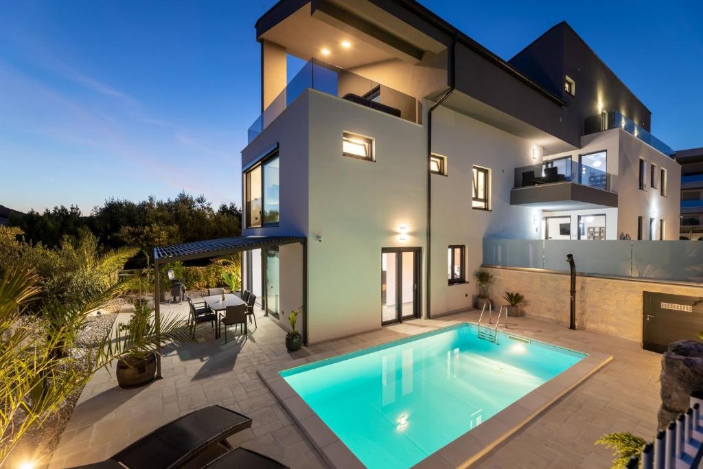 克尔克Luxury Villa Adria Apartments的一座房子前面设有游泳池