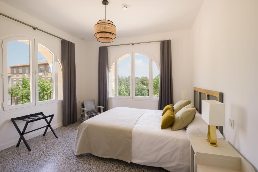 塔拉桑纳阿拉贡Torre Chiguita的白色卧室设有一张大床和两个窗户