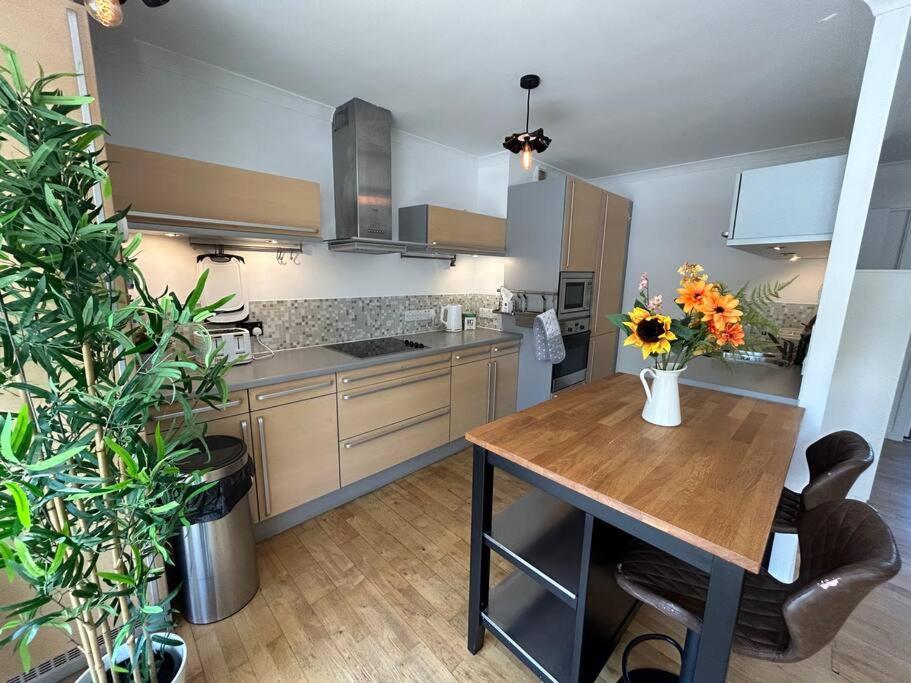 伦敦Homely apartment & Thames view的厨房配有带鲜花的木桌