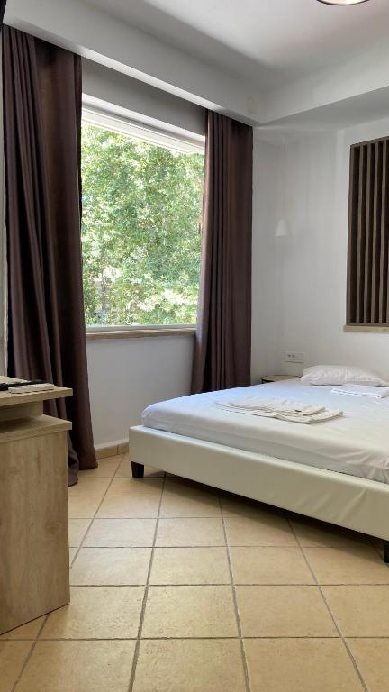 VrysesEmerald Suites的一间卧室设有一张大床和一个窗户。