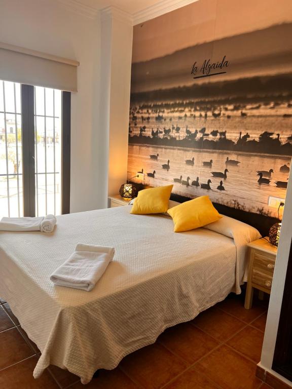 埃尔罗西奥Alojamiento Rural El Sombrero的一间卧室配有一张大床和毛巾