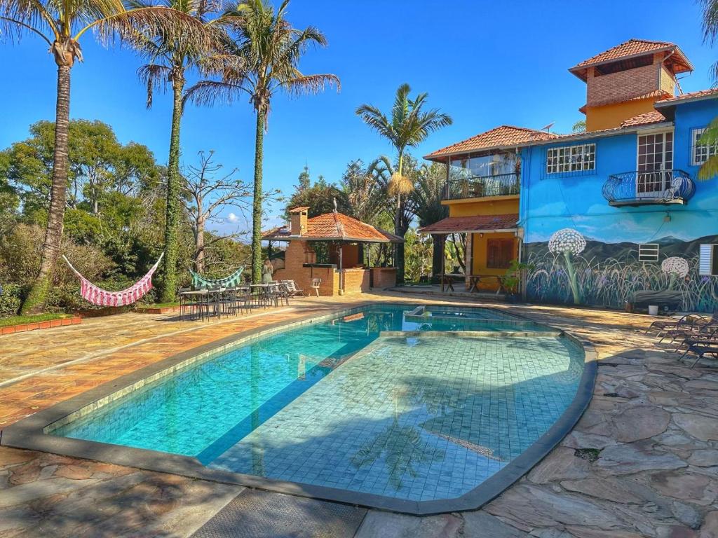 伊塔比里图Mirante do Espinhaço的棕榈树屋前的游泳池