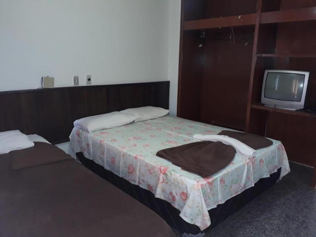 巴西利亚Beiruth Hotel的一间酒店客房,设有两张床和电视