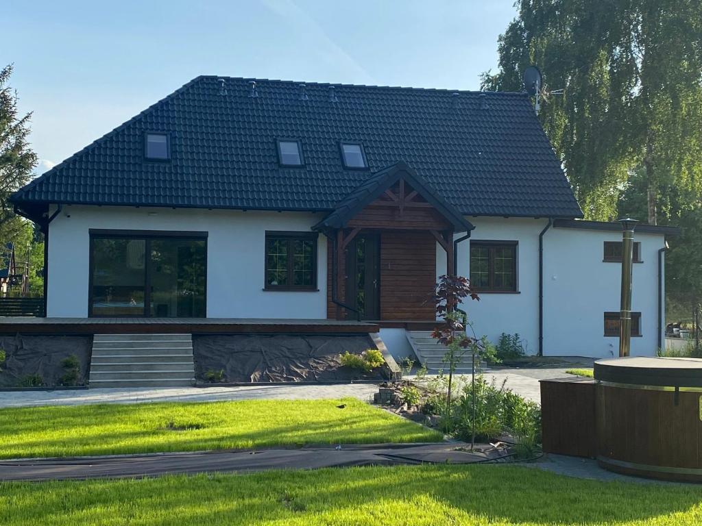 新古提Zakątek Śniardwy的黑色屋顶的白色房子