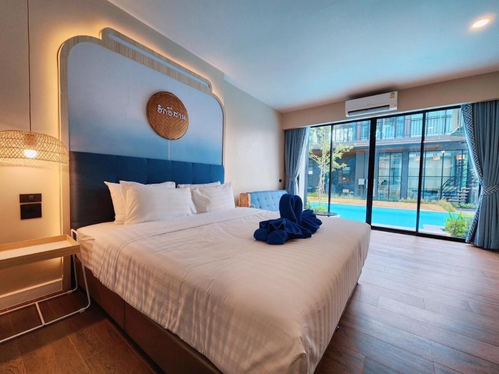 Ban Phang Khwang TaiPhu sakon ville hotel的一间卧室配有一张大床,上面有蓝色的弓