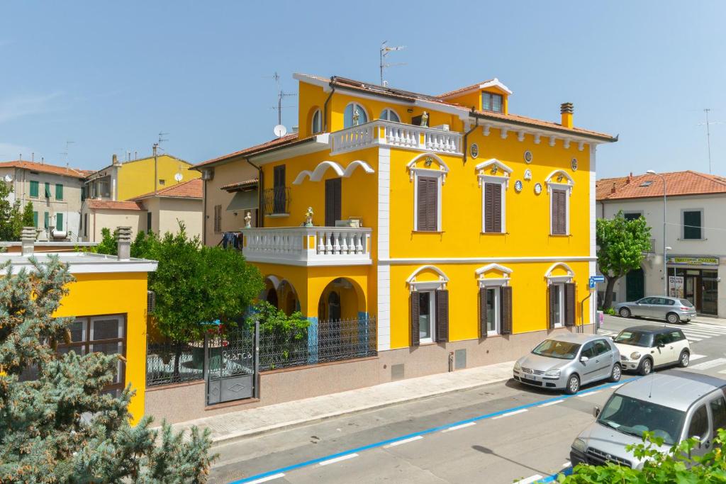 福洛尼卡La Casa di Bianca的一座黄色的建筑,前面有汽车停放