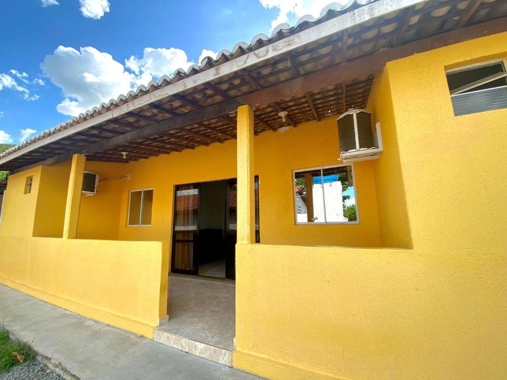 卡宁德圣弗朗西斯科Casa Condomínio Beira Rio的黄色的房子,有窗户和门