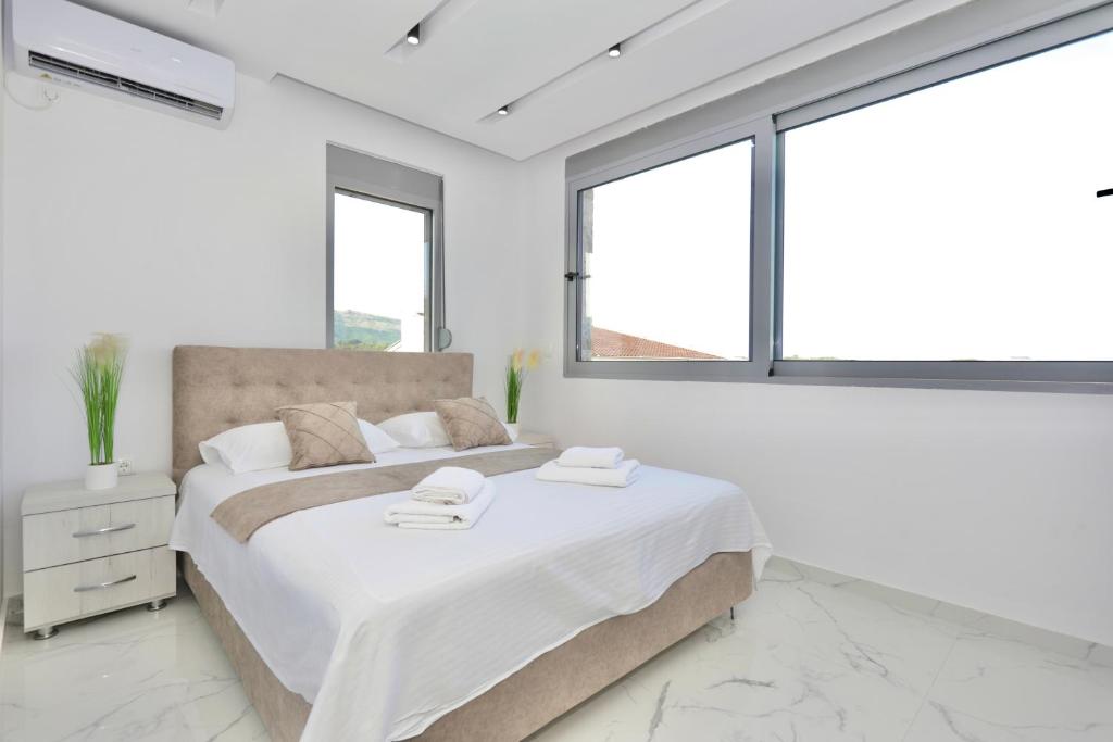 乌尔齐尼NESI Apartments的白色卧室设有大床和窗户