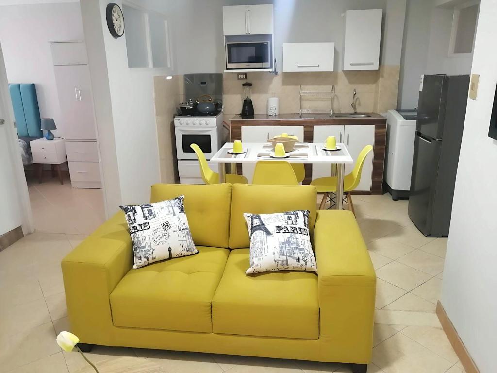 瓦拉斯Jacky's Home Bolognesi的厨房里一张黄色的沙发,配有桌子
