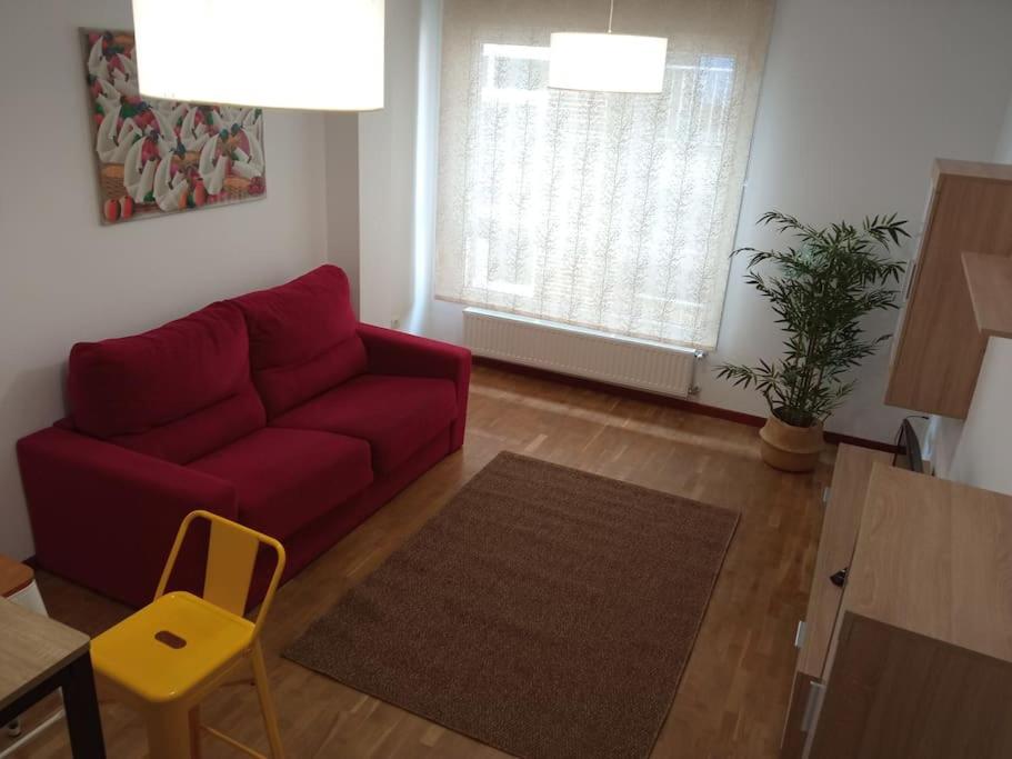 阿维莱斯Bonito Apartamento en Aviles的客厅配有红色的沙发和桌子