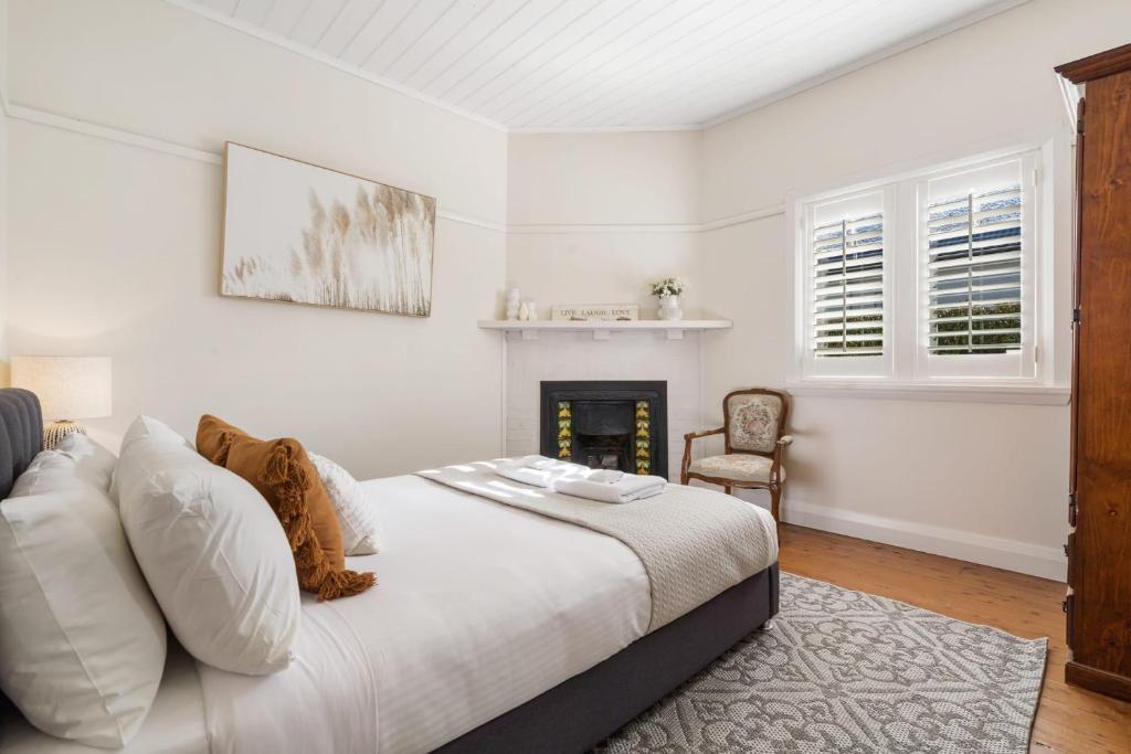 奥兰治Sampson Cottage - Historic Charm的一间白色卧室,配有一张床和一个壁炉