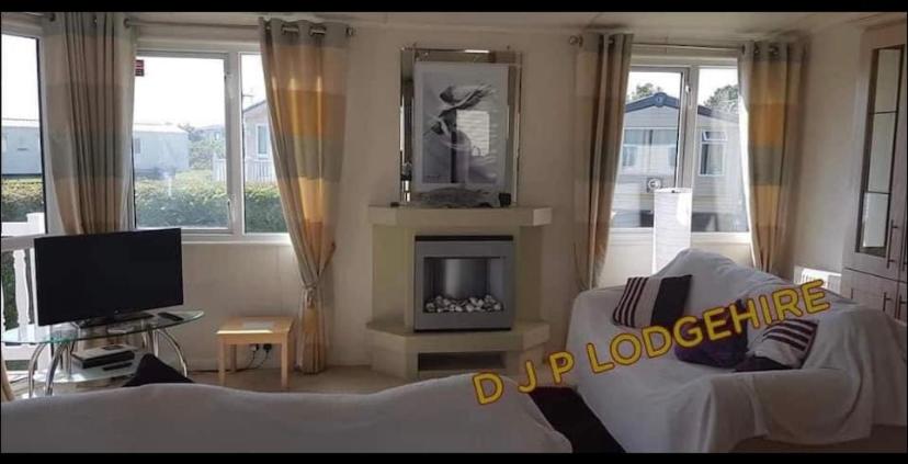 帕格汉姆Lodge for Hire的客厅配有白色沙发和壁炉
