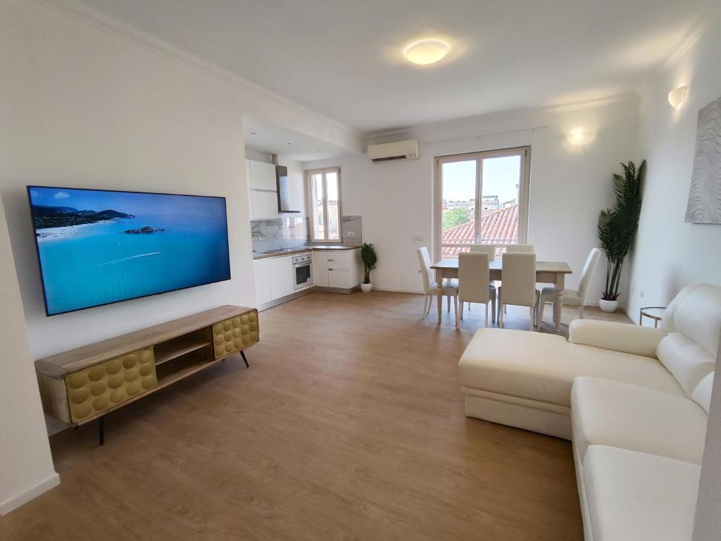 奥尔比亚Attico Vespucci Luxury Penthouse的客厅配有沙发和墙上的电视