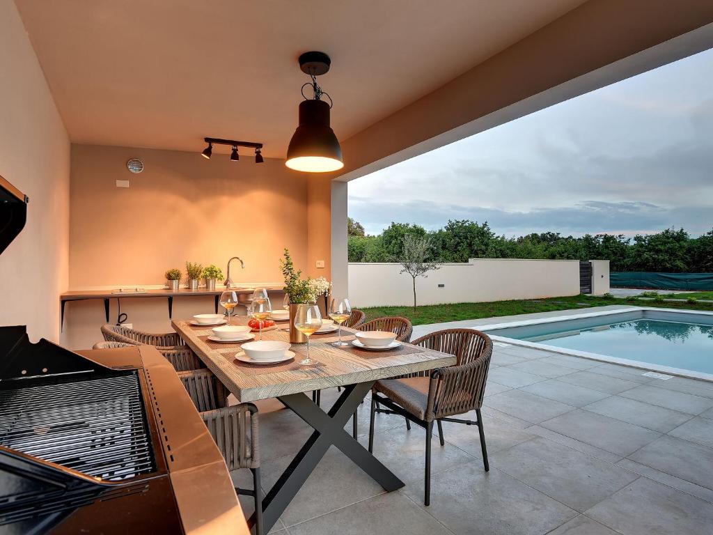 普拉Modern villa swimming pool , outdoor kitchen and fenced garden的一个带桌椅的庭院和一个游泳池