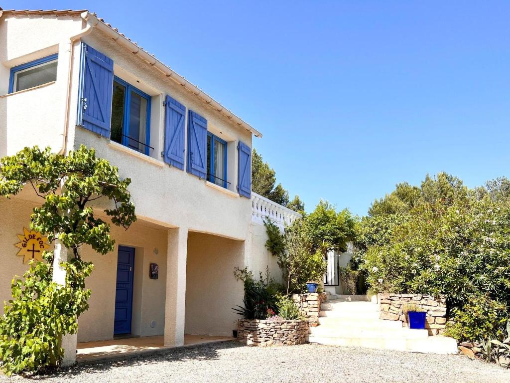 Pouzols-MinervoisModern villa with private pool的白色的房子,有蓝色的窗户和车道