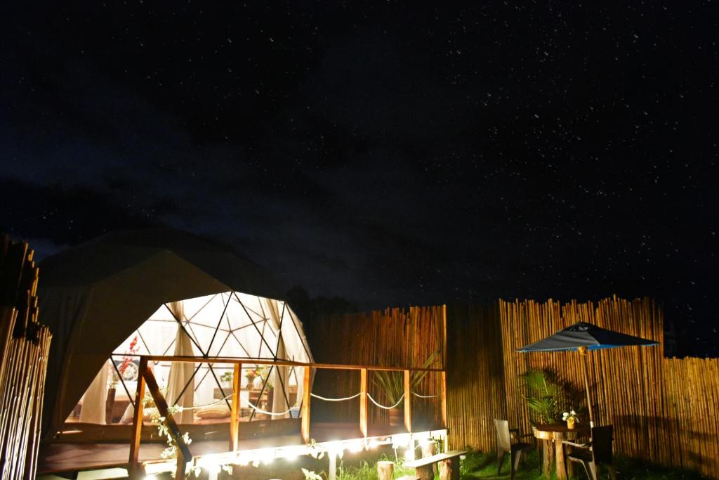 瓜塔维塔Glamping Claro de Luna的帐篷,配有桌子和雨伞