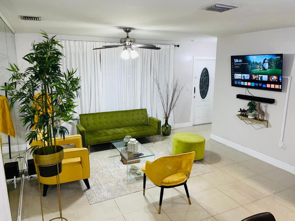 彭布罗克派恩斯Cozy Comfy House的客厅配有绿色沙发和黄色椅子