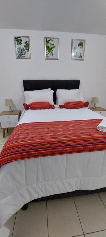 利马C&G Home Perú的一间卧室配有一张带红色枕头的大床