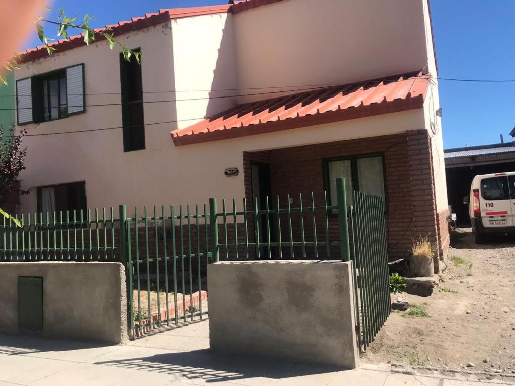 佩里托莫雷诺Family Hostel的前面有绿色围栏的房子