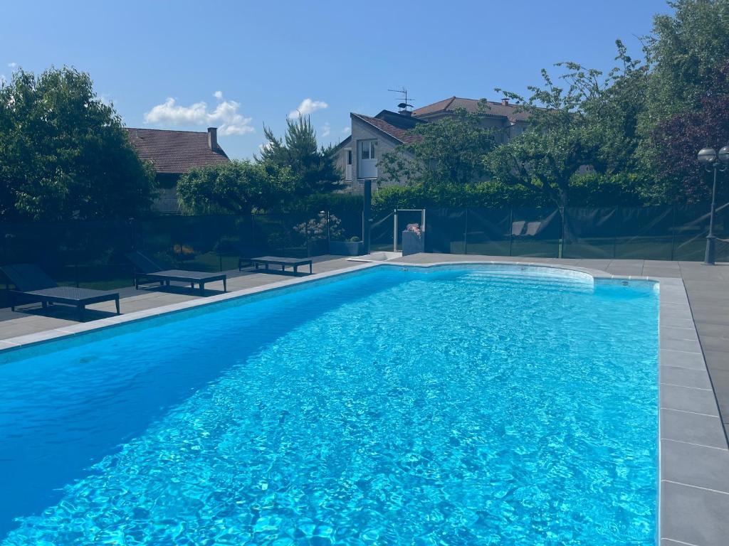 欧里亚克托马瑟之家酒店的大型蓝色游泳池周围设有2个长椅