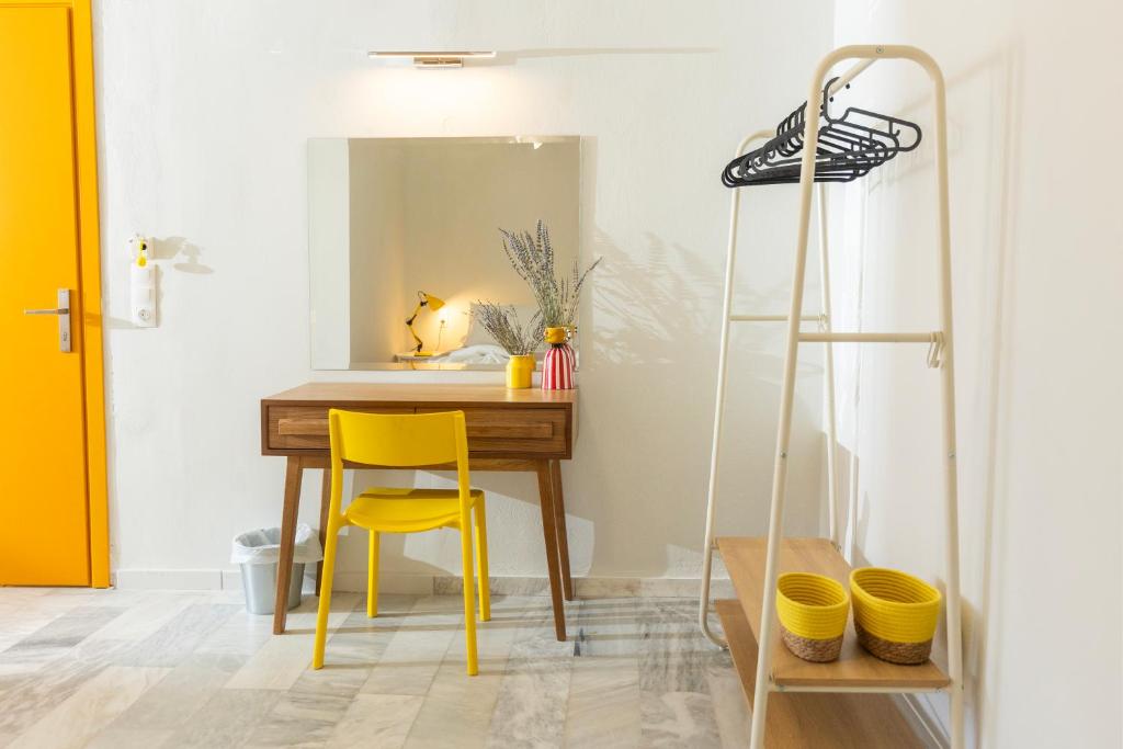斯基亚索斯镇Mondrian Guest House的一张桌子和一张黄色椅子,位于带镜子的房间