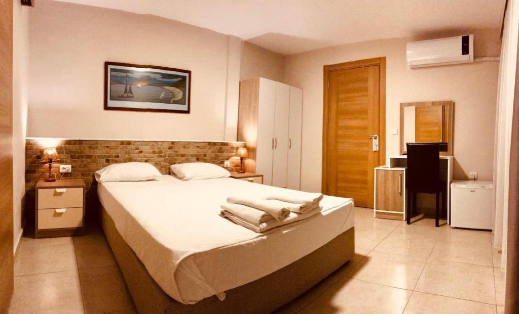 切什梅拜拉姆酒店的一间卧室配有一张大床和毛巾
