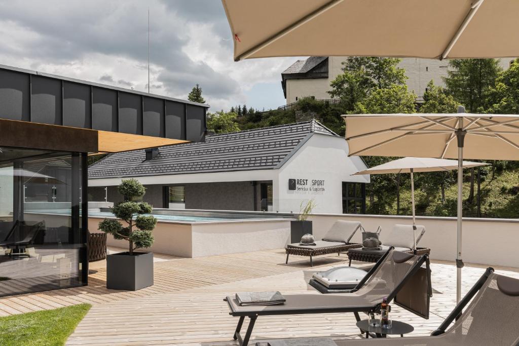 毛特恩多夫Rest Apartments & Suiten的一个带游泳池和遮阳伞的户外庭院