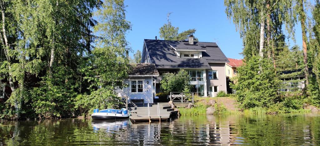 伦派莱Room by Lake 10 minutes from Tampere centrum的河上的房子,水上有船