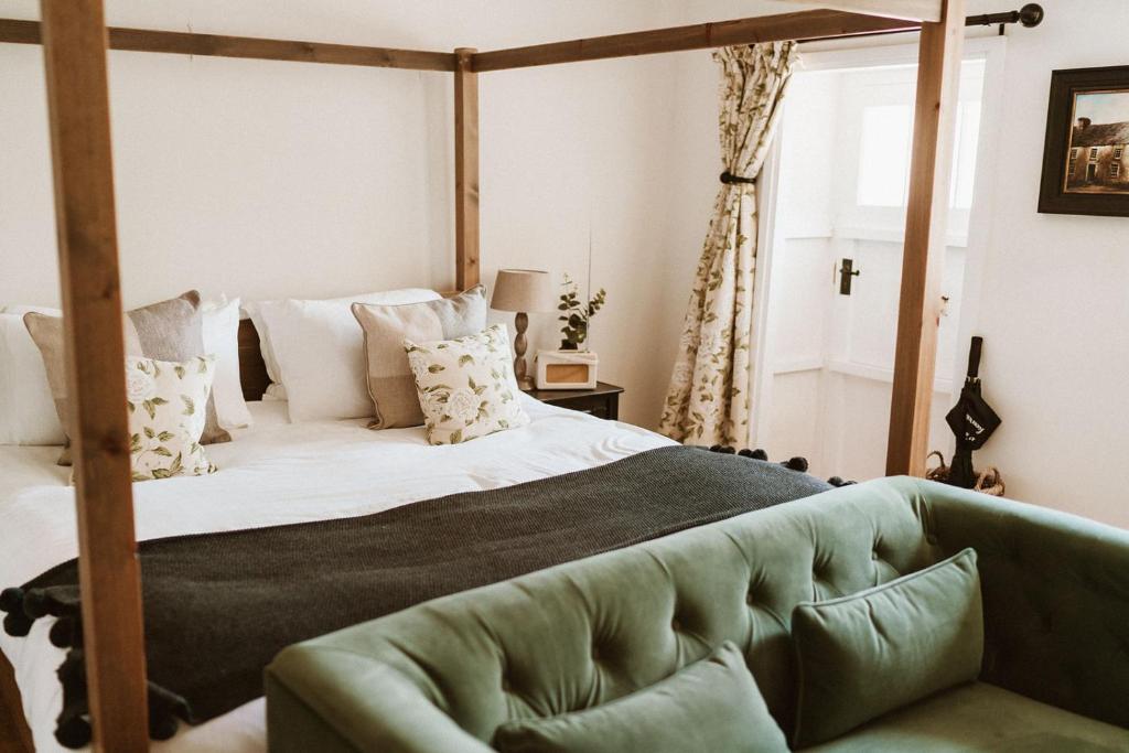 贝克韦尔Swallow Cottage, Bakewell的一间卧室配有一张大床和绿色沙发