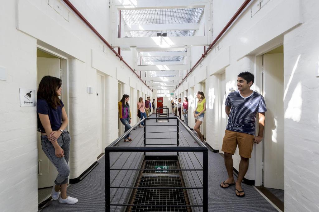 弗里曼特YHA Fremantle Prison的站在建筑物走廊的人