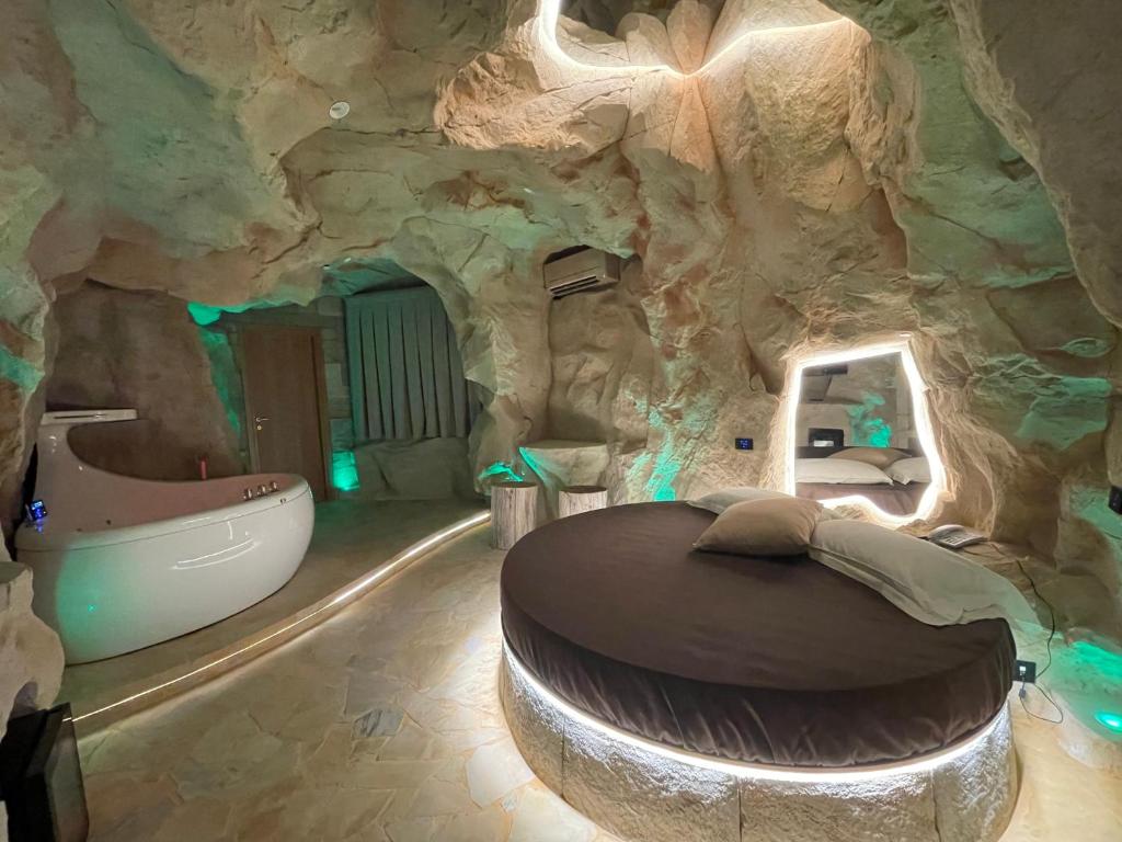 庞特卡格纳诺卡洛赛罗酒店的洞穴式卧室设有岩石墙内的浴缸