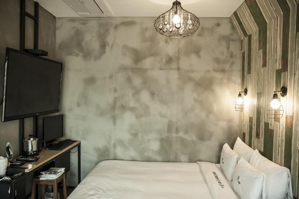首尔第31页酒店的一间卧室设有一张床和一面墙