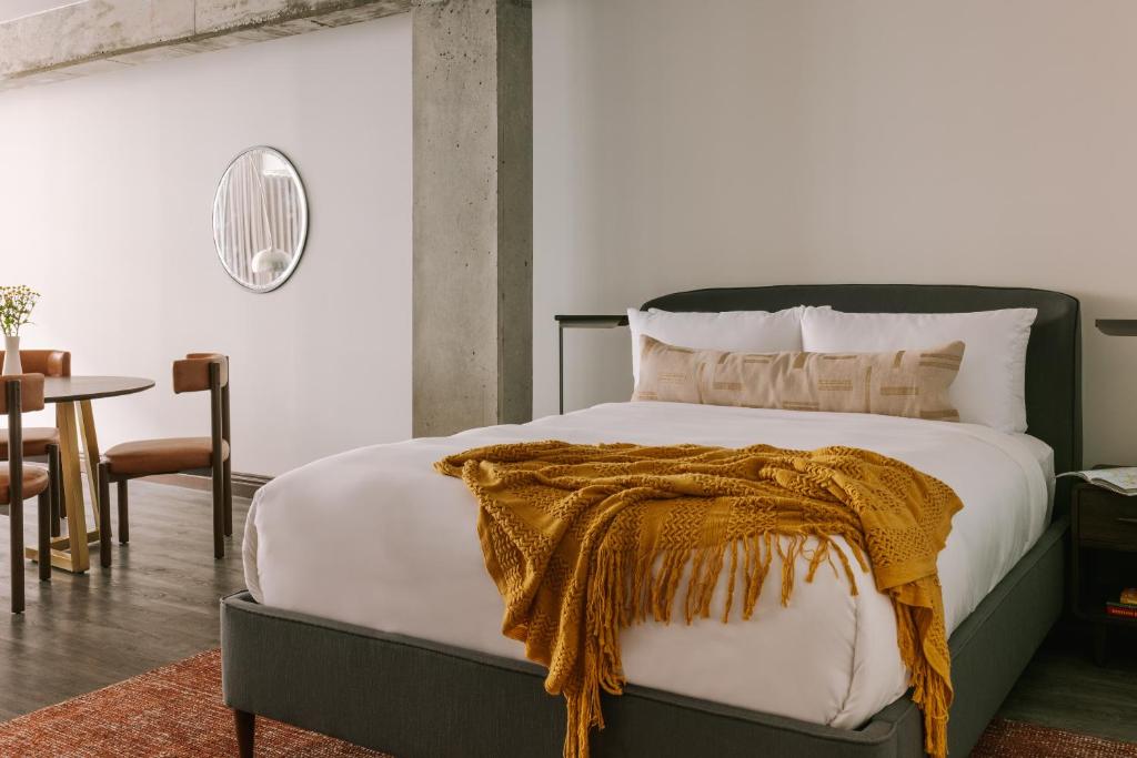 蒙特利尔Sonder Lambert的一间卧室配有一张床铺,床上有毯子