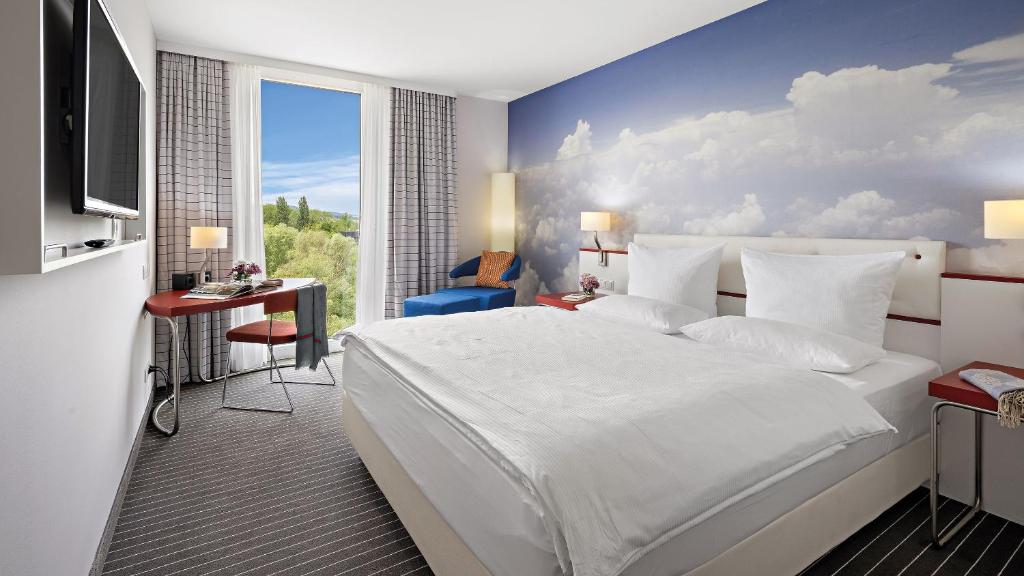 腓特烈港Hey Lou Hotel Friedrichshafen的卧室配有白色的床和蓝色的墙壁