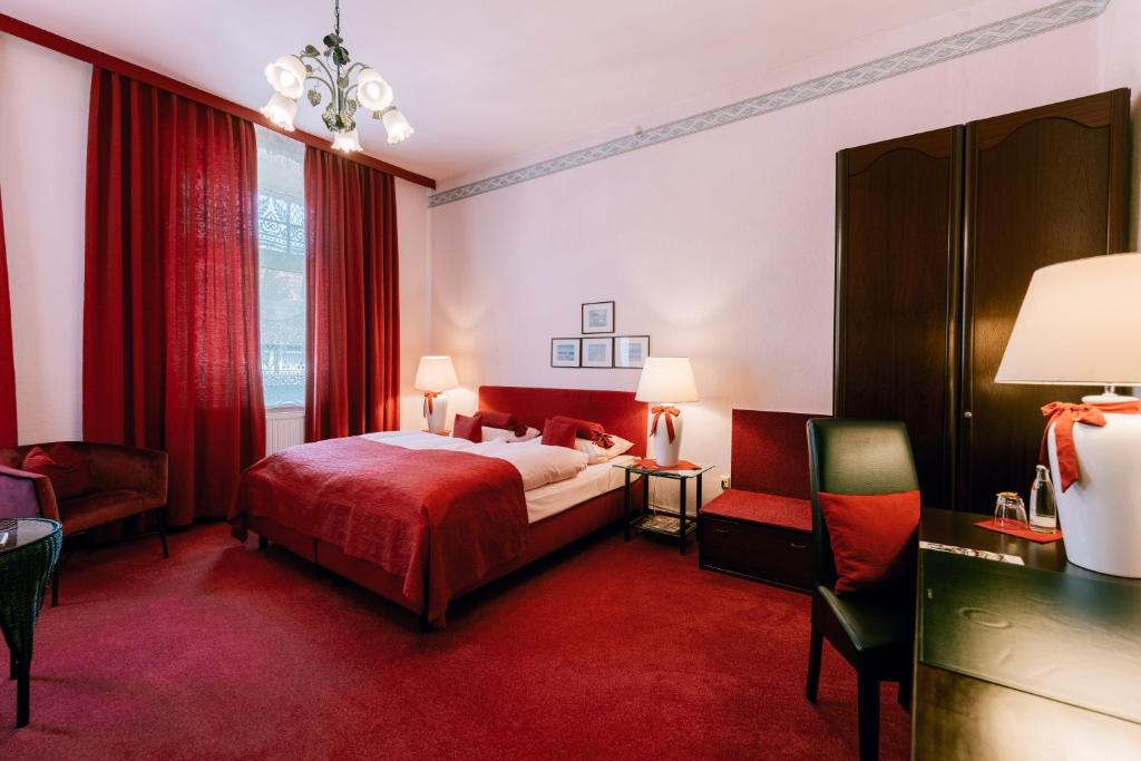 艾恩贝克Hotel Der Schwan的一间卧室配有一张床,铺有红色地毯