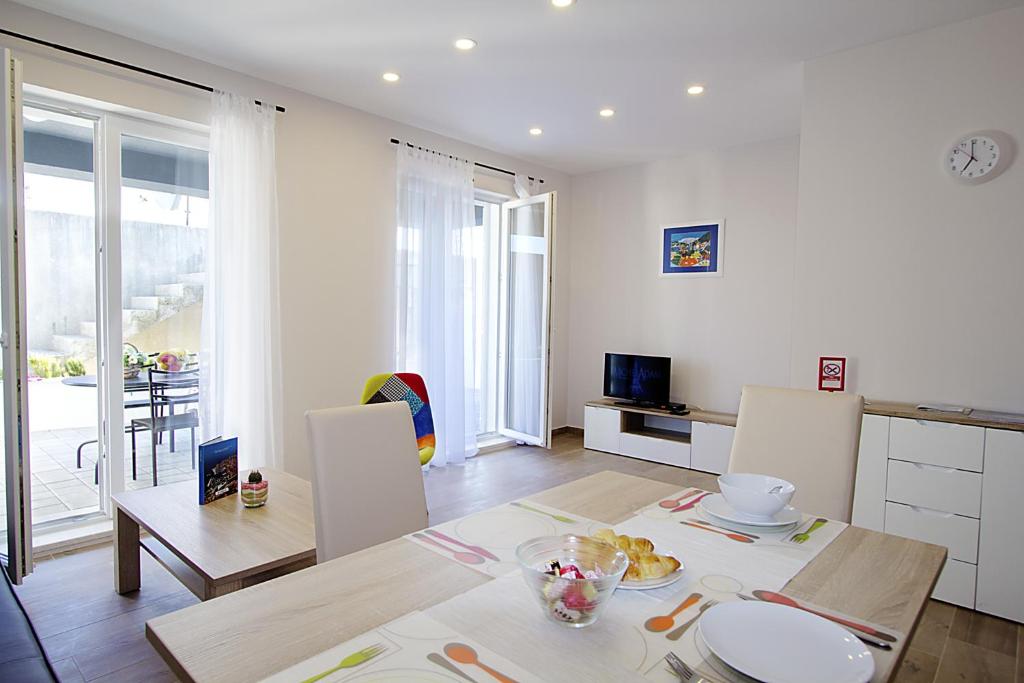 杜布罗夫尼克Apartments Ragusa Palace 1 Djardin的厨房以及带桌椅的起居室。