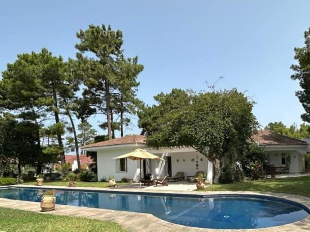 塔巴卡Villa avec piscine privée的房屋前有游泳池的房子
