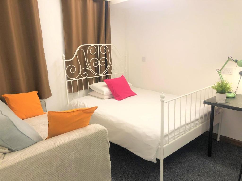 Tile HillBreeze Homstay的卧室配有白色的床和色彩缤纷的枕头