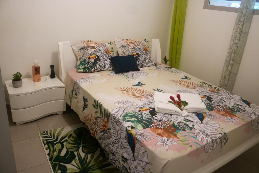 哥西尔Appartement d'une chambre avec balcon amenage et wifi a Le Gosier a 1 km de la plage的一间卧室配有一张带花卉床罩和枕头的床
