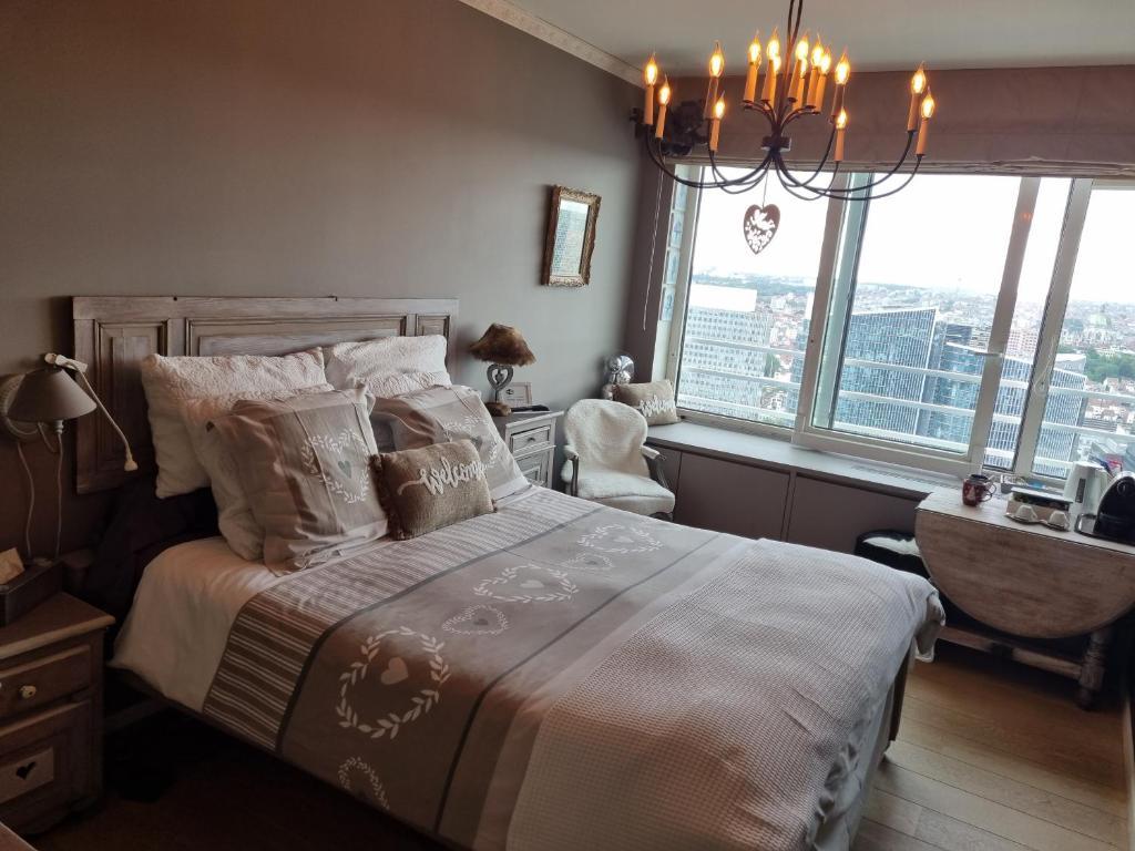 布鲁塞尔Romantic room in brussels sky的一间卧室配有一张带吊灯和窗户的床。