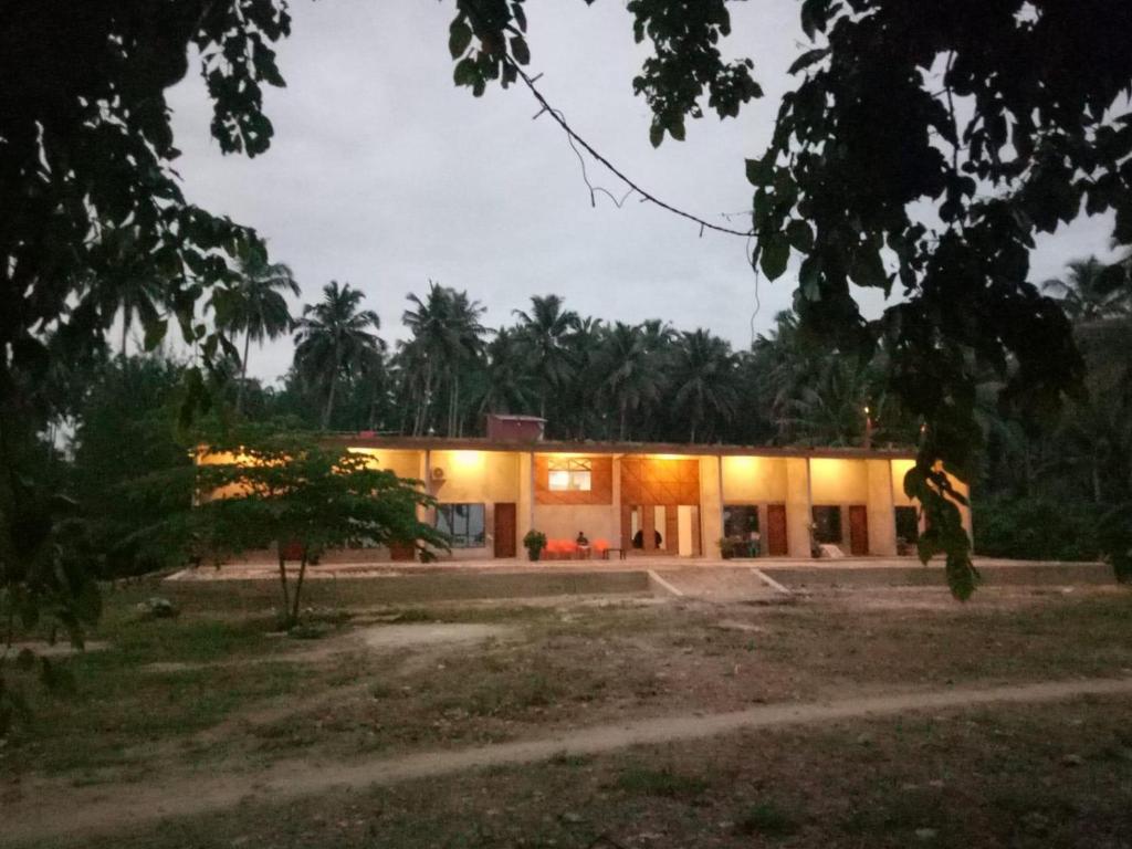 TelukdalemTaman Baloho Indah - Hotel & Resort的男人在晚上站在房子前面