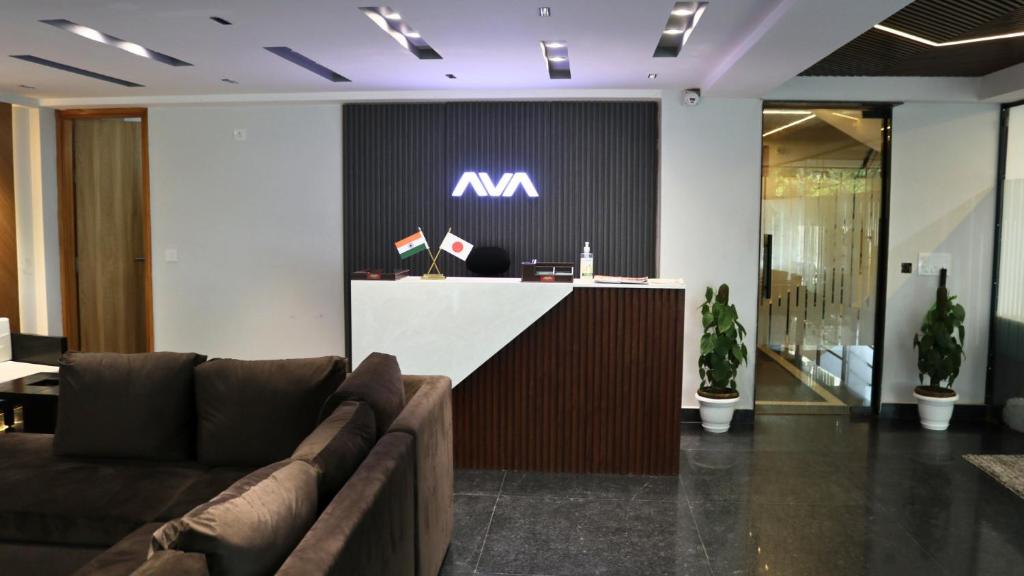 古尔冈AVA Hotels and Corporate Suites的办公室大堂设有带有m标志的前台