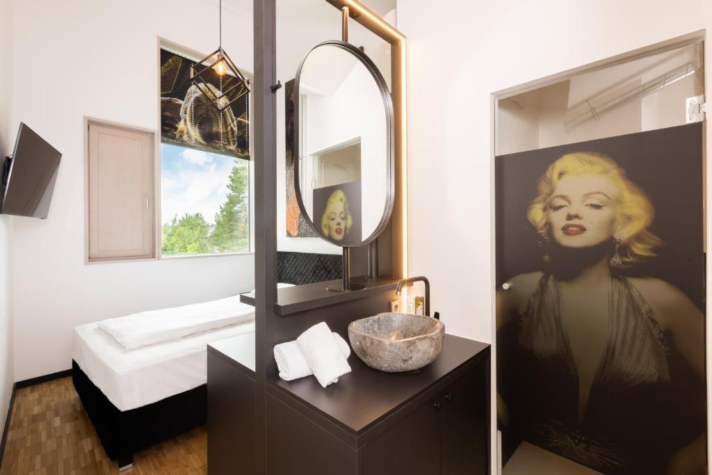 萨尔茨堡Das Edlinger的浴室设有大镜子、水槽和带水槽的梳妆台