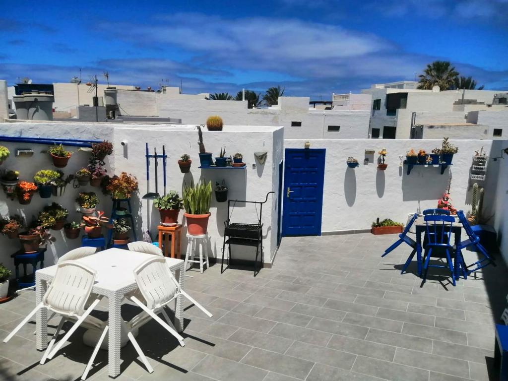 埃尔戈尔福3 bedrooms house at El Golfo Lanzarote 500 m away from the beach with furnished terrace and wifi的一个带桌椅的庭院和白色的建筑