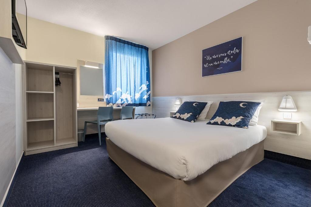 克莱蒙费朗艾斯酒店的酒店客房设有一张大床和一张书桌。