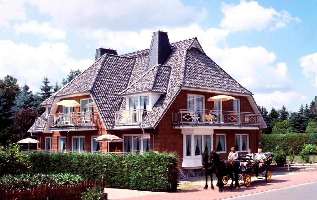 施内沃丁根Landhaus Heide的大房子前面的马车