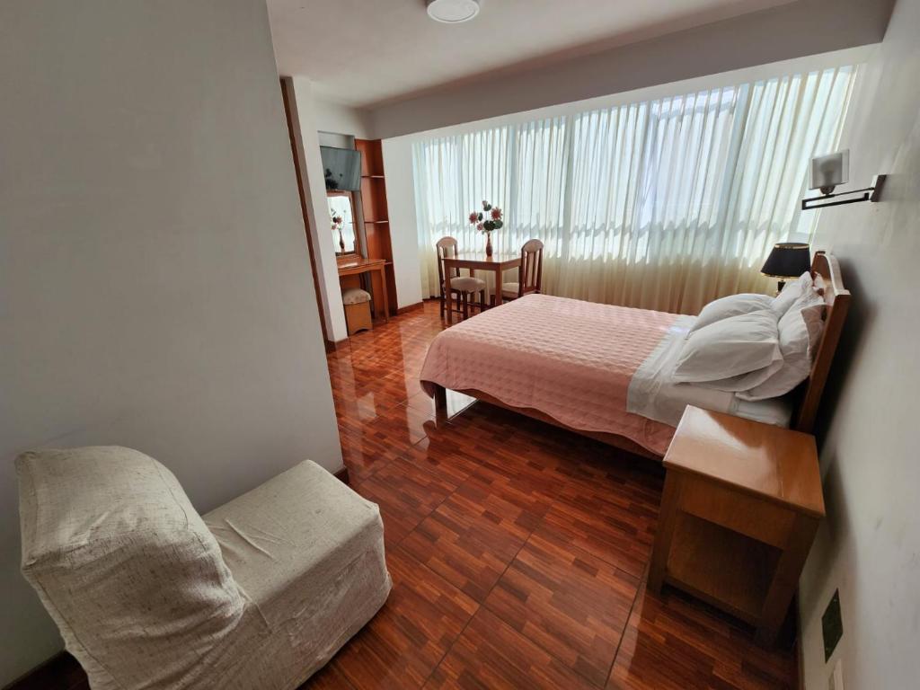 塔克纳Hotel Oceano Mit的一间卧室,卧室内配有一张床和一把椅子