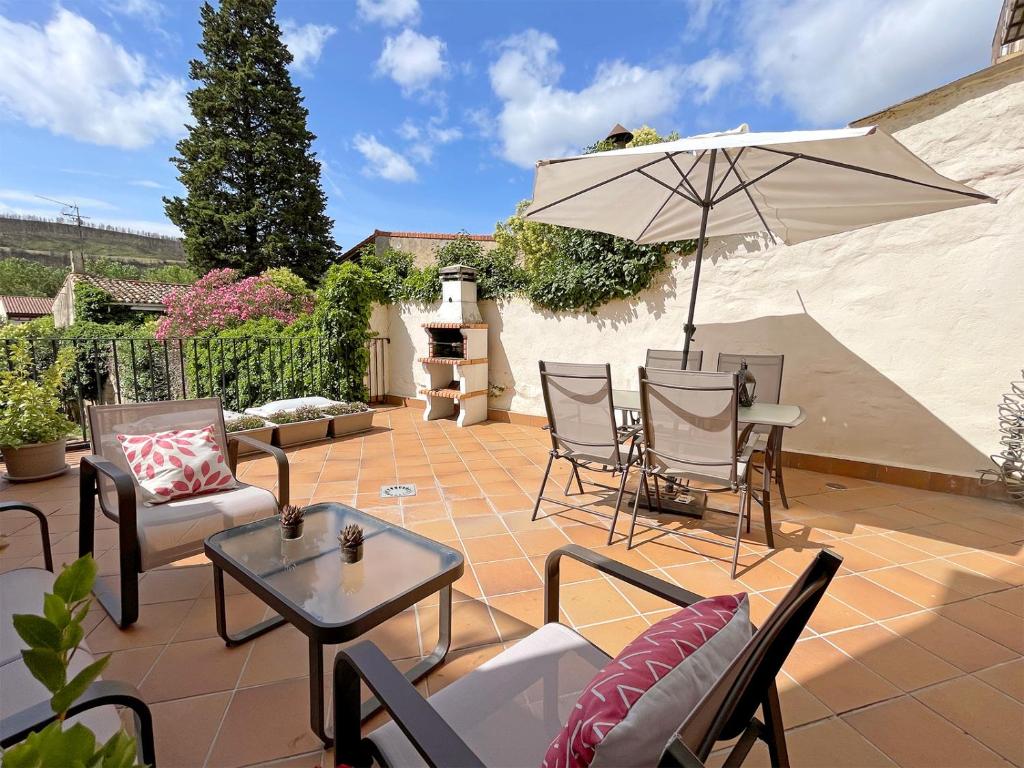蓬特拉雷纳Apartamentos Puente La Reina的庭院配有桌椅和遮阳伞。