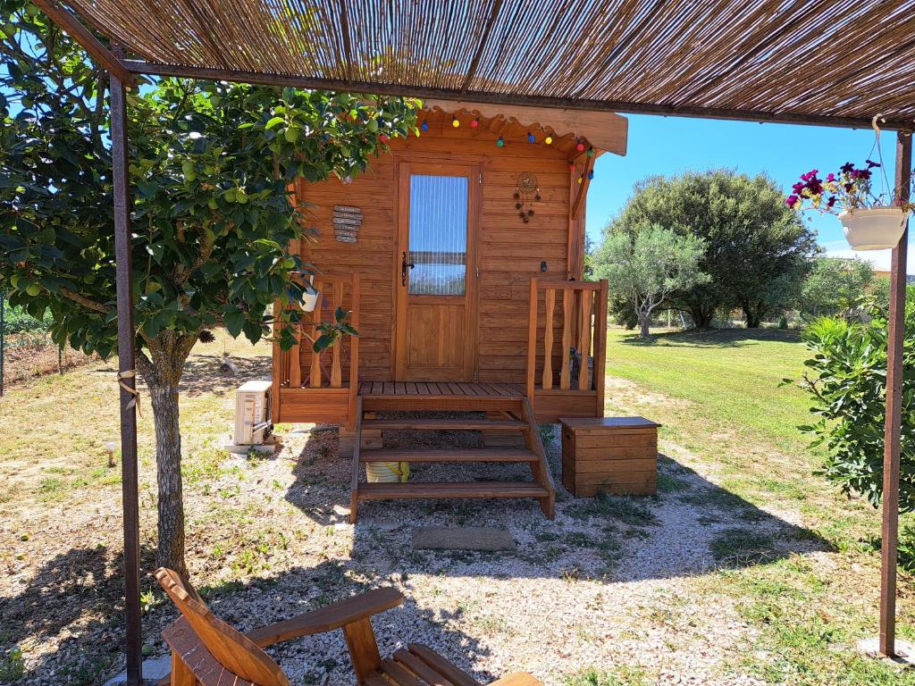 弗维沃Roulotte en bois的小木屋配有长凳和遮阳伞